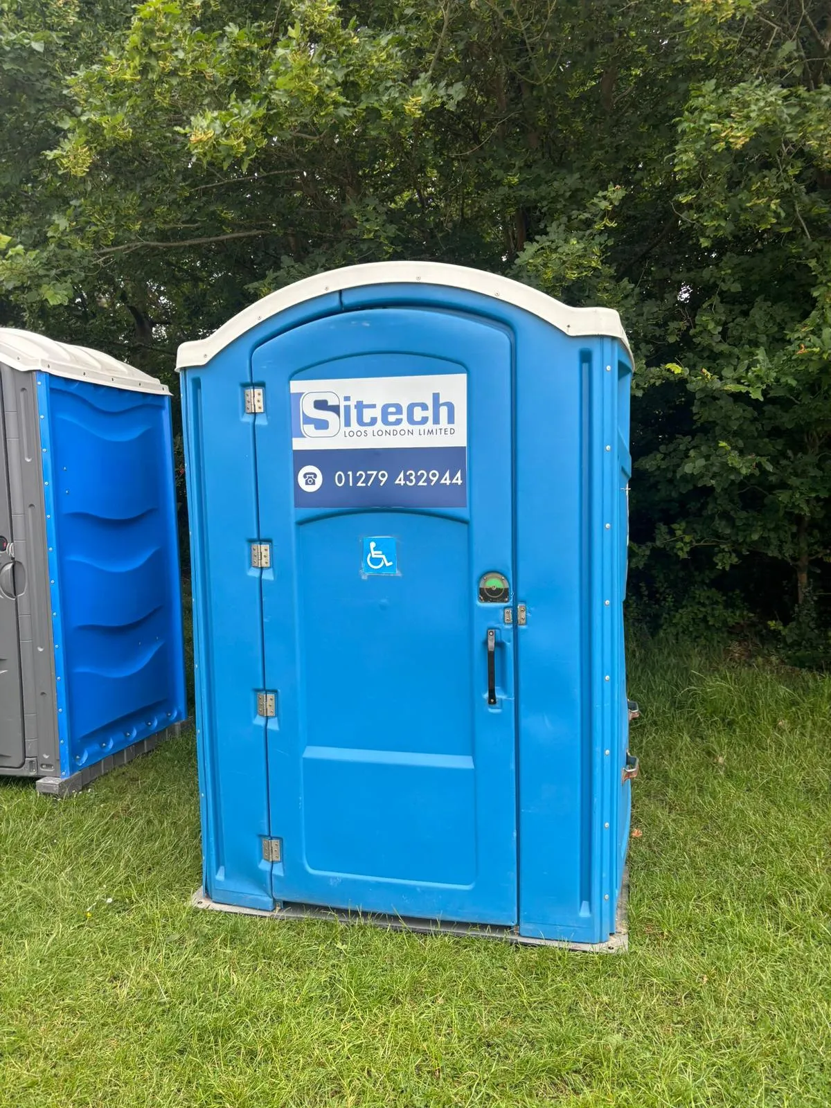 Sitech Loos London disabled-access temporary toilet marked with a wheelchair symbol, positioned on a UK site next to a standard unit