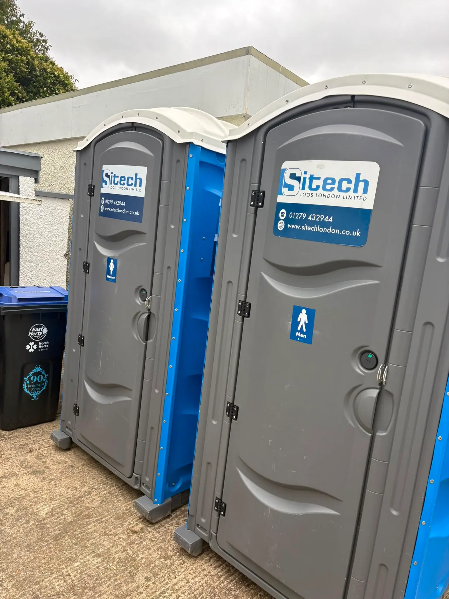 Pair of Sitech men's and women's portable toilets sited at a venue